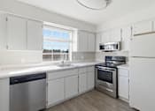 Thumbnail 1 of 29 - A kitchen with white cabinets and stainless steel appliances.