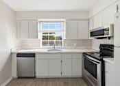 Thumbnail 2 of 29 - A kitchen with white cabinets and a window.