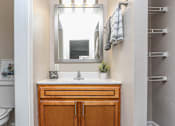 Thumbnail 6 of 21 - A bathroom with a white sink and a mirror above it.