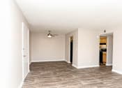 Thumbnail 5 of 21 - A room with a ceiling fan and wooden flooring.
