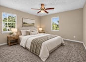 Thumbnail 8 of 27 - Bedroom with a bed, ceiling fan, and two lamps at Arbours at Victoria Place in Prattville, AL