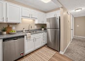 Thumbnail 2 of 27 - Virtually staged apartment kitchen with white cabinets and a stainless steel refrigerator at Arbours at Victoria Place in Prattville, AL