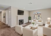 Thumbnail 3 of 26 - A living room with a fireplace and a flat screen TV mounted on the wall.