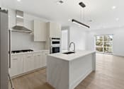 Thumbnail 15 of 29 - A modern kitchen with a large island and stainless steel appliances.