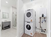 Thumbnail 21 of 29 - A laundry room with a washer and dryer stacked on top of each other.