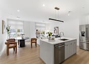 Thumbnail 8 of 29 - A modern kitchen with a large island and stainless steel appliances.