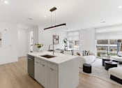 Thumbnail 5 of 29 - A modern kitchen with a large island and a dining area with a view.