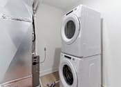 Thumbnail 20 of 29 - A washing machine and dryer stacked on top of each other in a laundry room.