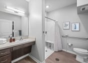 Thumbnail 12 of 19 - a bathroom with a shower sink and toilet and a mirror