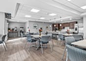 Thumbnail 15 of 19 - a community dining room with tables and chairs and a kitchen