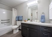 Thumbnail 10 of 26 - a bathroom with a toilet sink and shower and a mirror at Arbors at Sunday Village, Austin