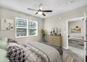 Thumbnail 7 of 26 - a bedroom with a bed and a ceiling fan at Sunday Village, Austin, TX