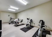 Thumbnail 26 of 35 - A well-lit gym with a variety of exercise equipment.