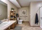 Thumbnail 6 of 35 - A bathroom with a white toilet, sink, and a white shower.
