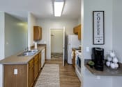 Thumbnail 10 of 35 - A kitchen with a refrigerator, sink, and a coffee sign on the wall.