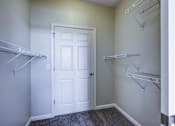 Thumbnail 5 of 35 - A white door is in the middle of a room with two shelves on either side.