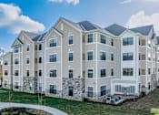 Thumbnail 15 of 20 - A row of modern apartment buildings with a clear blue sky above.