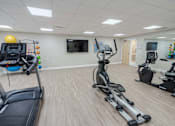 Thumbnail 9 of 20 - A gym with treadmills, elliptical machines, and other exercise equipment.