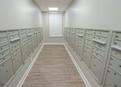 Thumbnail 14 of 20 - A long hallway with a series of mailboxes on the wall.