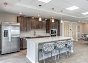 Thumbnail 18 of 20 - A modern kitchen with a white island and stainless steel appliances.