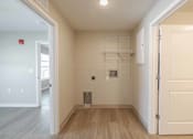 Thumbnail 8 of 19 - A white door is open to a room with a wood floor and white walls.