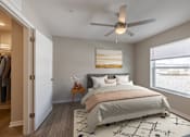 Thumbnail 6 of 19 - A bedroom with a large bed and a ceiling fan.