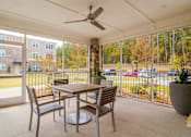 Thumbnail 10 of 16 - A patio with a table and chairs and a ceiling fan at Sweetwater Point in Douglasville, GA