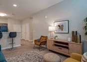 Thumbnail 14 of 16 - A living room with a brown chair and a brown cabinet at Sweetwater Point in Douglasville, GA