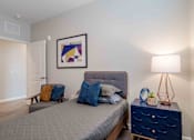 Thumbnail 16 of 16 - A bedroom with a bed, nightstand, and lamp at Sweetwater Point in Douglasville, GA