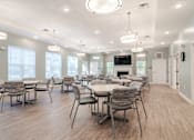 Thumbnail 9 of 16 - a large dining room with tables and chairs and a fireplace at Sweetwater Point in Douglasville, GA
