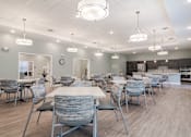Thumbnail 5 of 16 - a large dining room with tables and chairs and a kitchen at Sweetwater Point in Douglasville, GA
