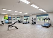 Thumbnail 4 of 16 - a gym with cardio machines and weights at Sweetwater Point in Douglasville, GA