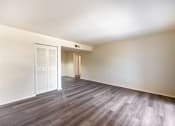 Thumbnail 7 of 14 - A room with a white door and a wooden floor.
