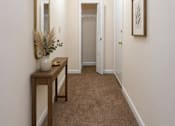 Thumbnail 4 of 14 - A hallway with a brown carpet and white walls.
