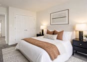 Thumbnail 3 of 14 - A bedroom with a large bed and a painting on the wall.