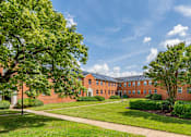 Thumbnail 2 of 14 - A large building with a lawn in front of it.