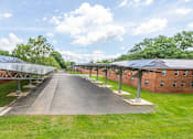 Thumbnail 11 of 14 - A long building with a green lawn in front.