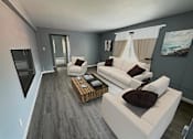 Thumbnail 3 of 22 - A modern living room with a white sofa and a wooden coffee table.at The Summit, Syracuse, 13210