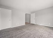 Thumbnail 5 of 30 - A room with a carpeted floor and two doors.