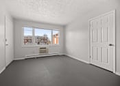 Thumbnail 6 of 30 - A room with a large window and a view of a building outside.