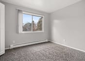 Thumbnail 10 of 30 - A room with a window and a carpeted floor.