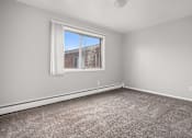Thumbnail 13 of 30 - A room with a large window and a carpeted floor.