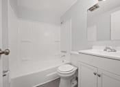 Thumbnail 14 of 30 - A white bathroom with a toilet, sink, and bathtub.