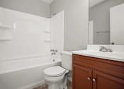 Thumbnail 15 of 30 - A white toilet sits next to a bathtub in a bathroom.