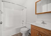 Thumbnail 7 of 30 - A white bathroom with a toilet, sink, and shower.