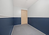 Thumbnail 18 of 30 - A room with a closed door and a grey floor.