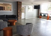 Thumbnail 20 of 30 - A grey couch and a brown table are in a room with a glass window.