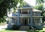Thumbnail 30 of 30 - A two-story house with a front porch and a staircase leading to the entrance.