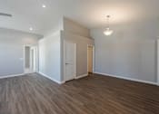 Thumbnail 14 of 15 - A room with wooden flooring and white walls.
