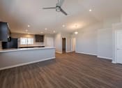 Thumbnail 13 of 15 - A spacious room with wooden flooring and a ceiling fan.
